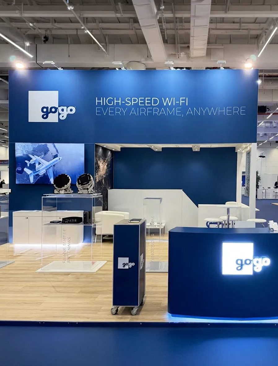 AIX 2026 Gogo booth with a navy fascia reading High-speed Wi-Fi, every airframe, anywhere, antennas in acrylic cases and a backlit Gogo logo counter