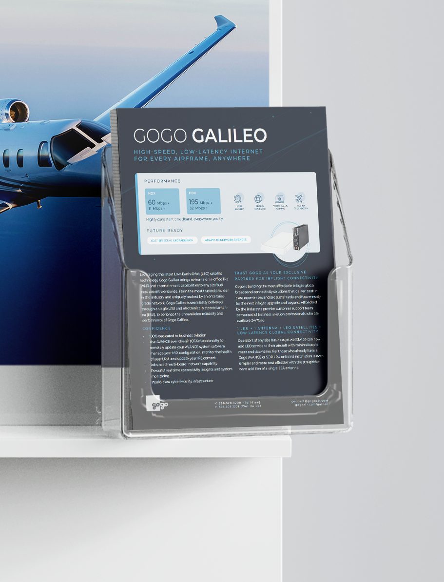 Printed Gogo Galileo sheet in a clear acrylic holder on a white booth counter, in front of a business jet graphic